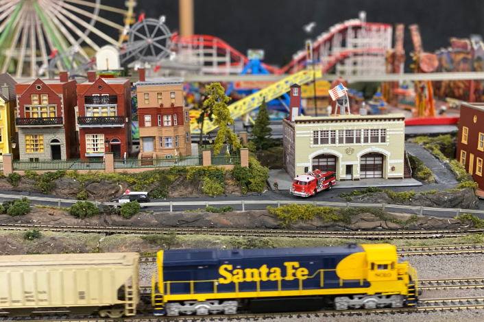 Model Train with an amusement park scene in the background