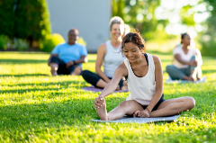 Patrons doing Pilates in a grassy field