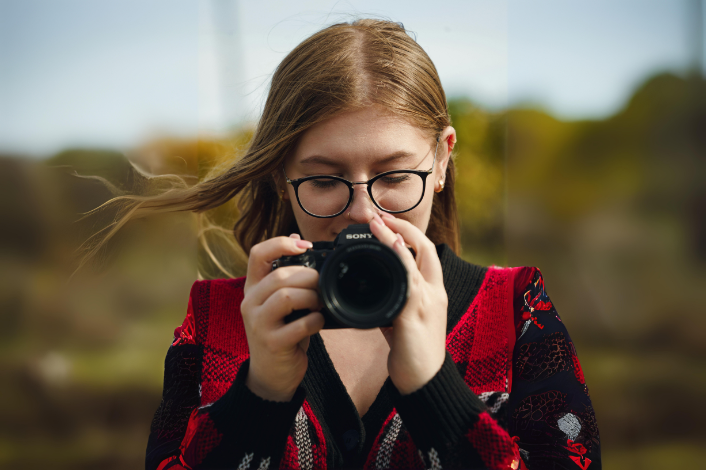 Teenage girl holding a digital camera