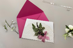 Card with natural pressed flowers and a pink envelope